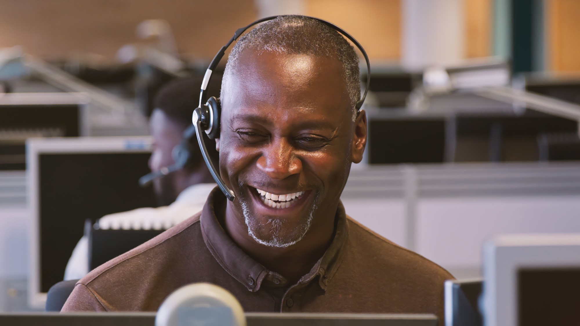 Friendly support agent speaking with a patient on a headset